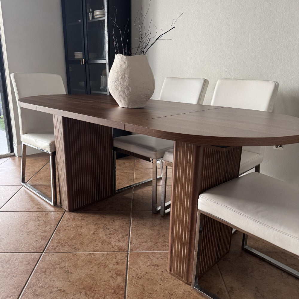 Dining table with chairs in a room with tiled floor and white walls