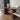Dining table with chairs in a room with tiled floor and white walls