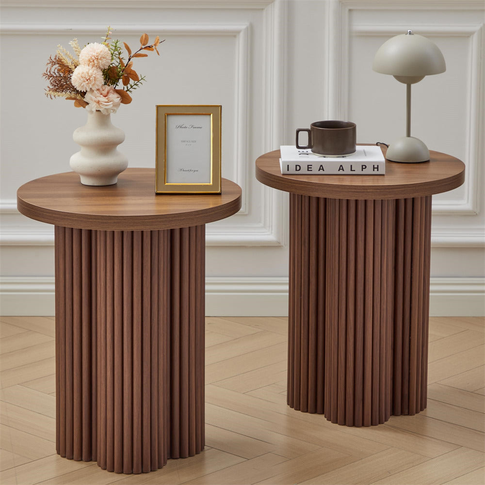 Two wooden side tables with decorative items on a wooden floor.