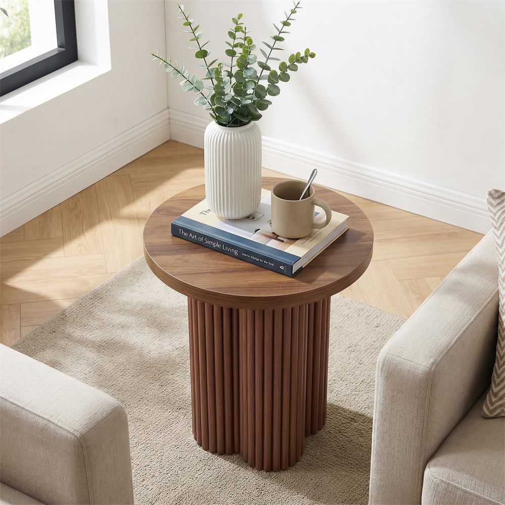 Wooden side table with a plant, book, and mug in a living room setting.