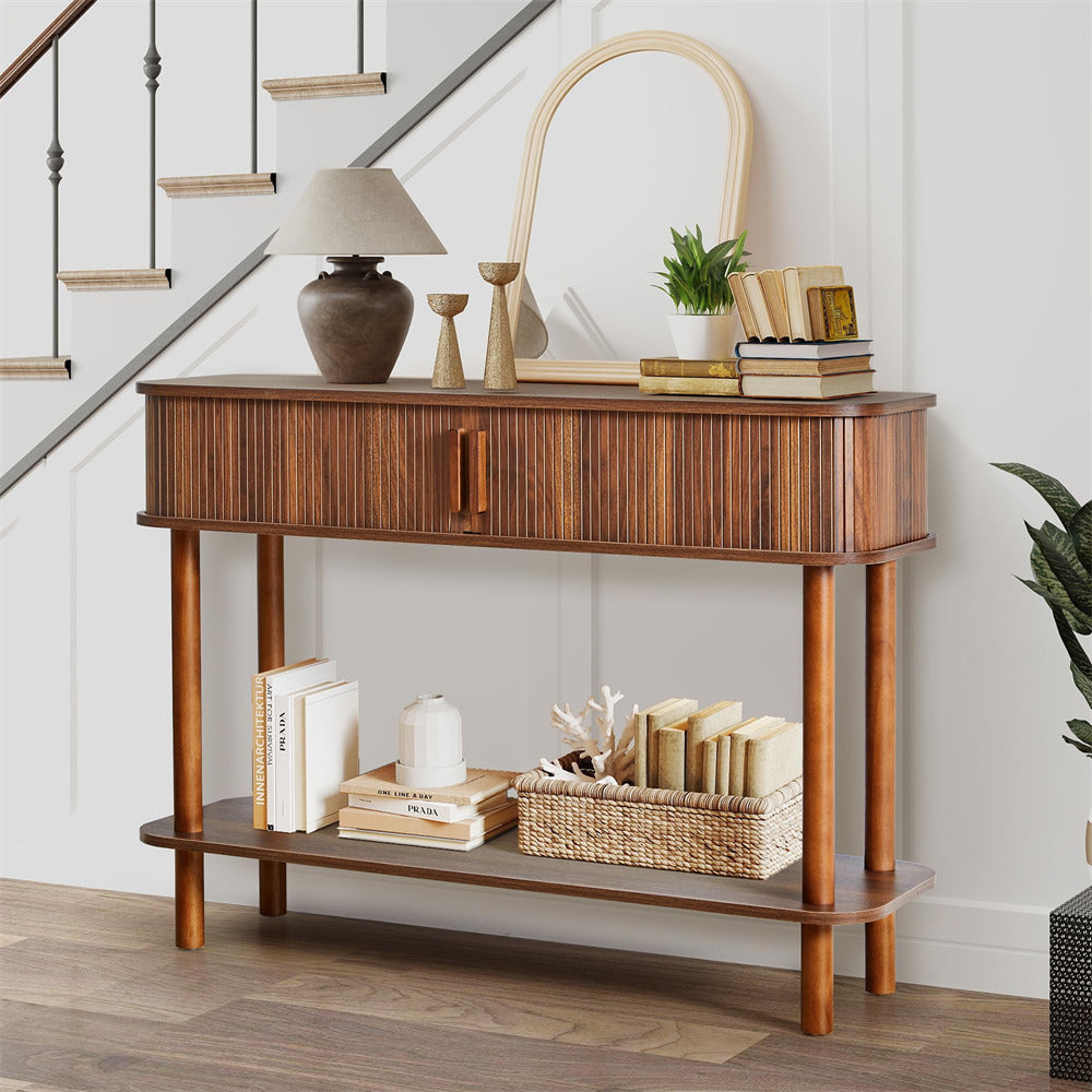Wooden console table with decorative items in a room with a staircase.
