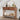 Wooden console table with decorative items in a room with a staircase.