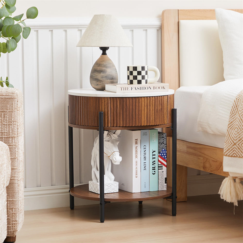 Wooden side table with books, a lamp, and a mug next to a bed.