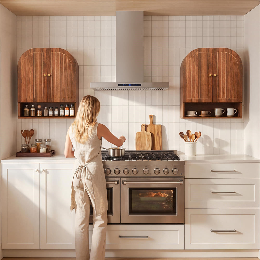 Woman cooking in a modern kitchen with wooden cabinets and white tiled walls.