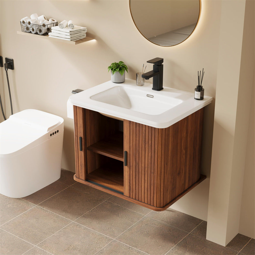 Bathroom with wooden vanity, white sink, and round mirror.
