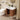 Bathroom with wooden vanity, white sink, and round mirror.