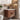 Bathroom setup with wooden vanity, sink, and shelves with products.