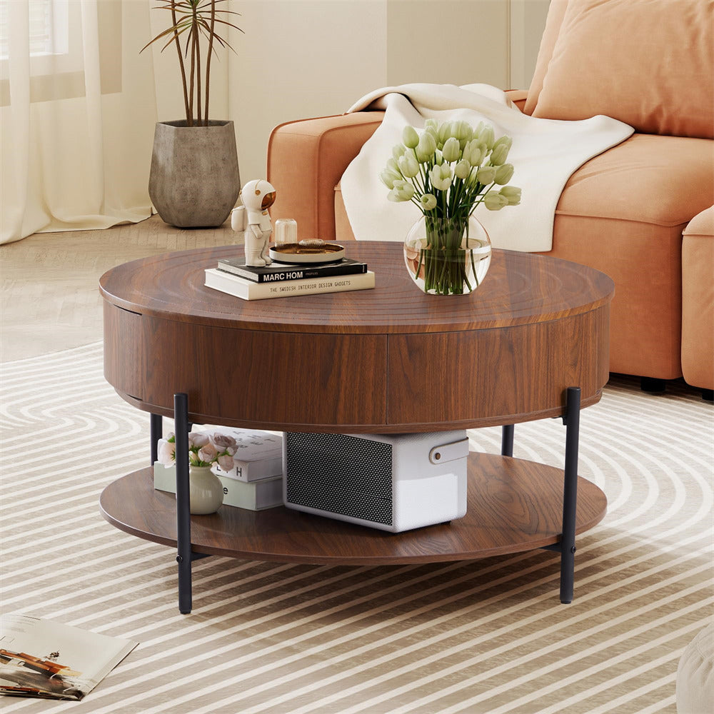 Round wooden coffee table with books, a vase of flowers, and decorative items in a living room setting.