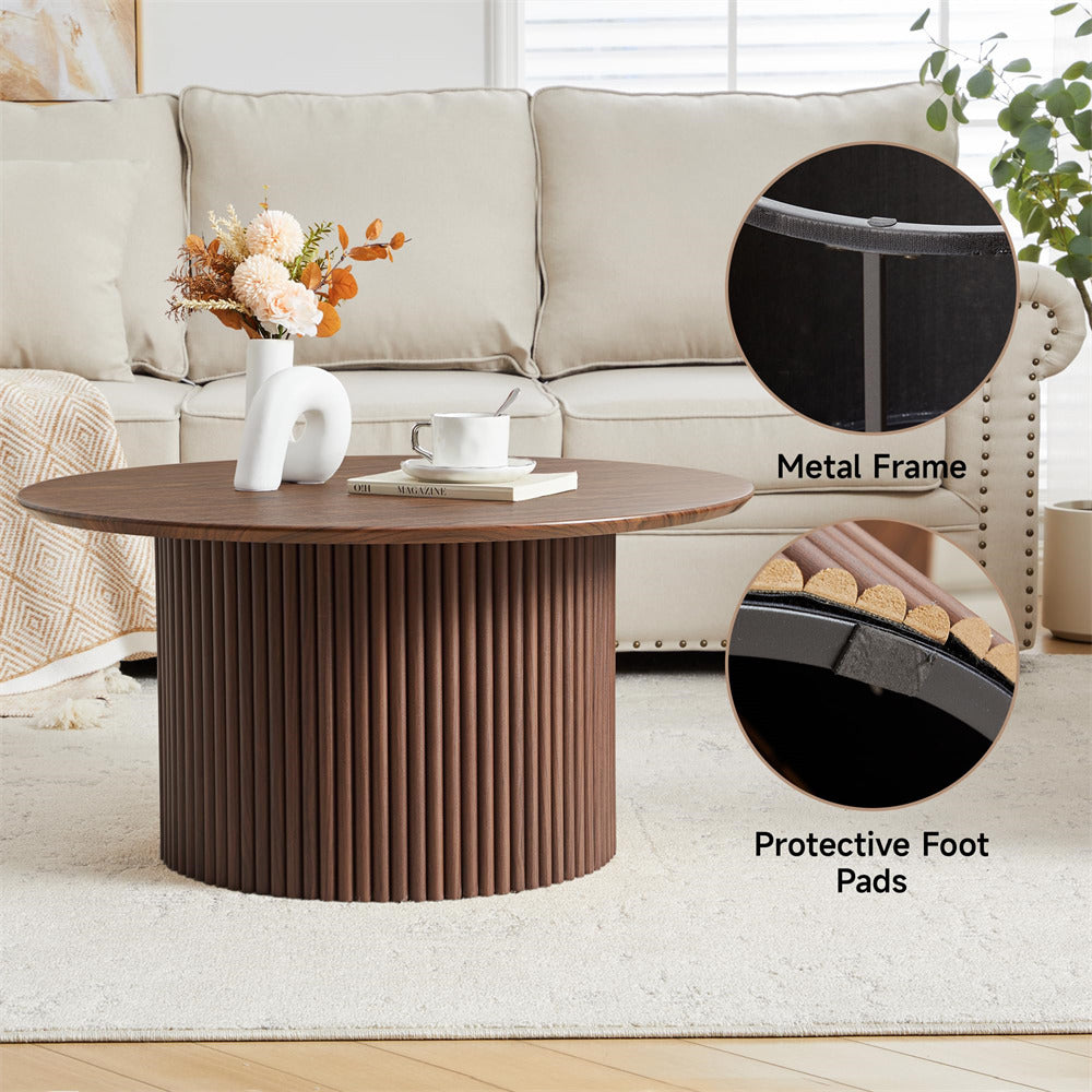 Round wooden coffee table with metal frame and protective foot pads in a living room setting.