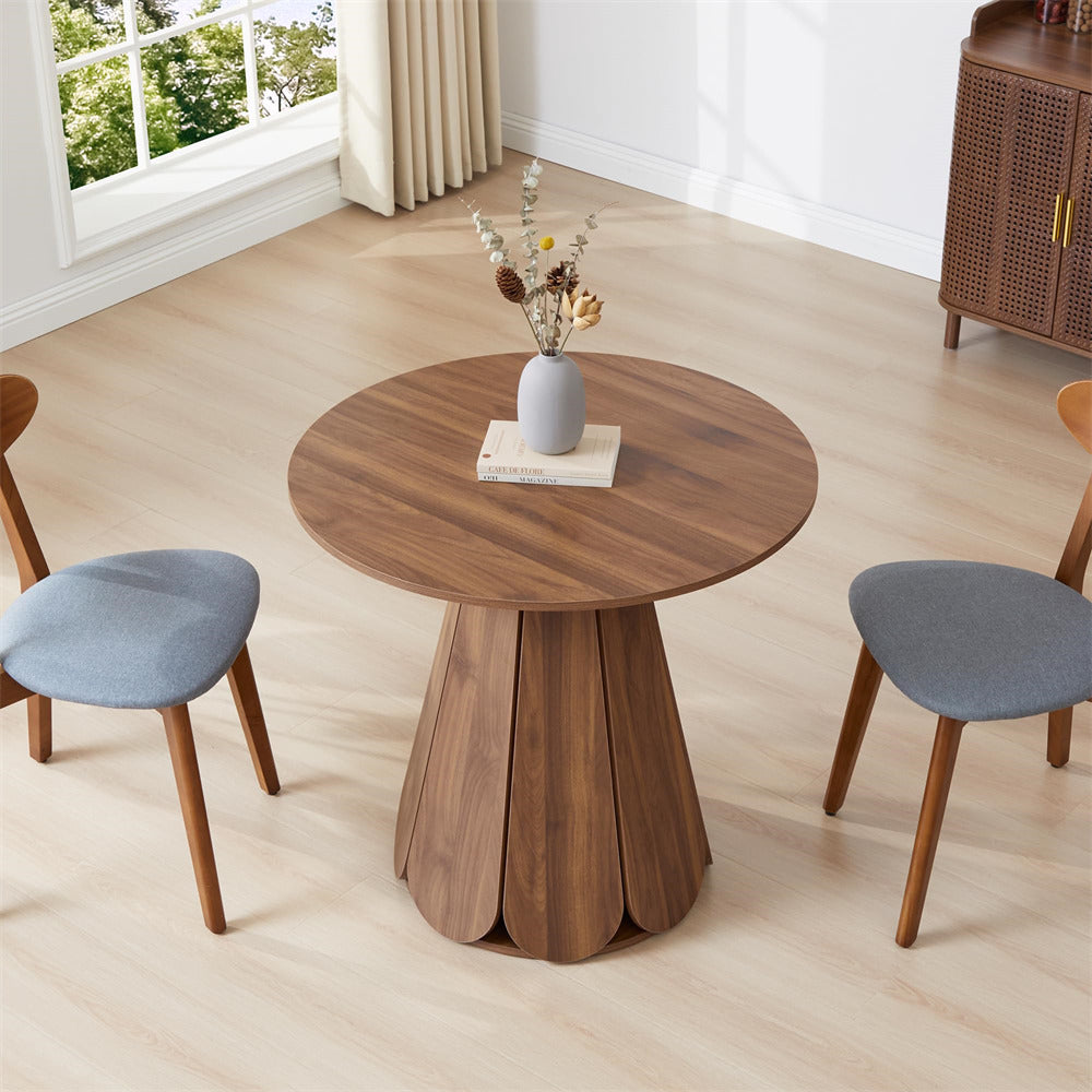 Wooden round table with a vase of flowers in a room with chairs and a cabinet.