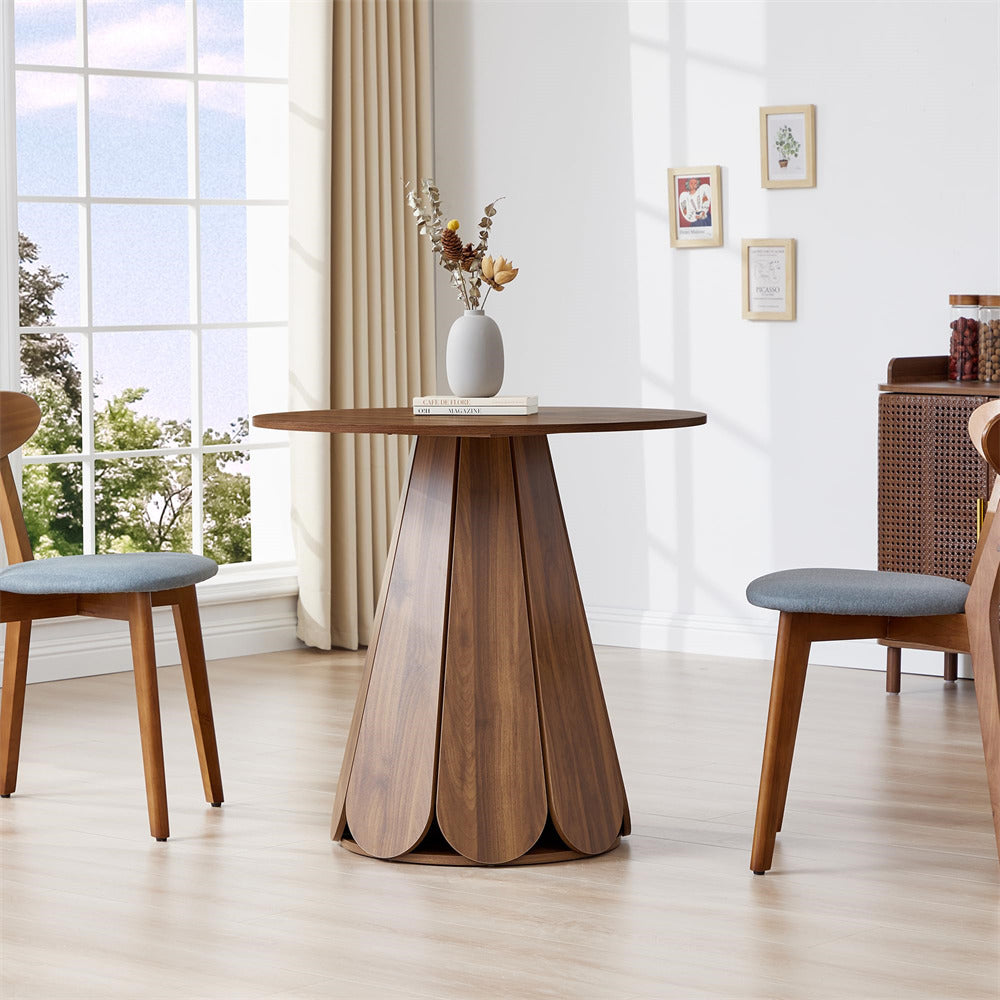 Dining table with a unique base design in a bright room with large windows.