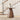 Wooden side table with a vase on it in front of a staircase
