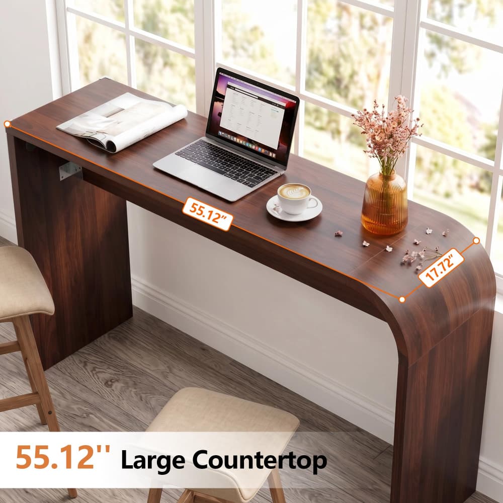 A dark wood curved desk shown in a bright room with windows, styled with a laptop, notebook, coffee cup, and vase. Orange dimension overlays indicate the desk is 55.
