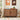 Wooden cat litter box in a room with cat-themed decor and toys on the floor.