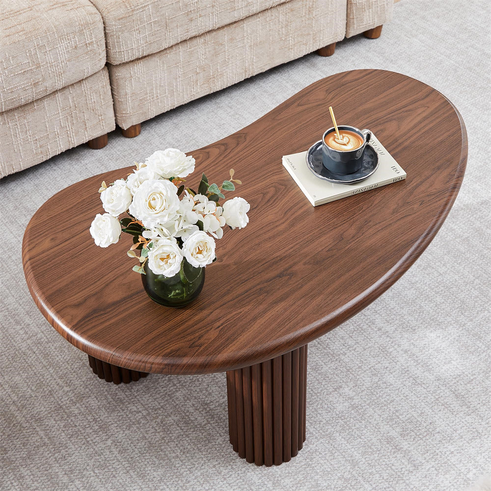 Wooden coffee table with flowers and a cup in a living room setting