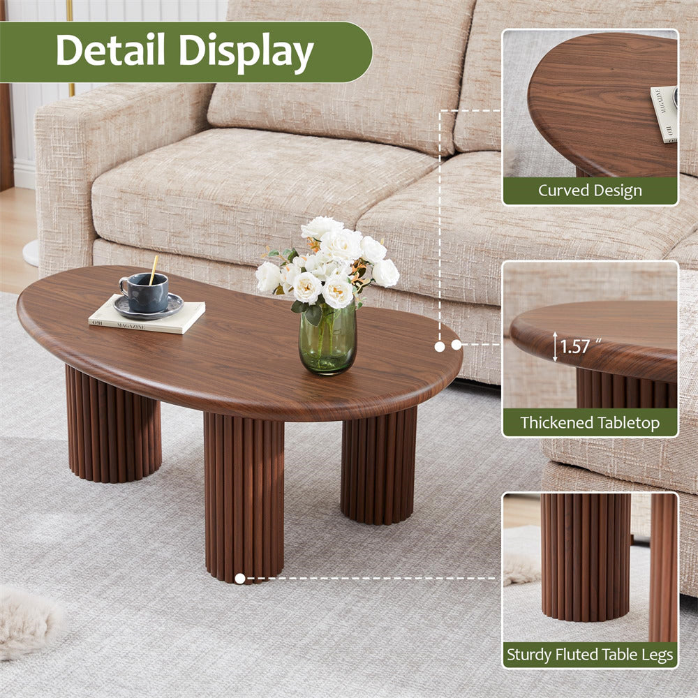 Wooden coffee table with curved design, thickened tabletop, and sturdy fluted legs in a living room setting.