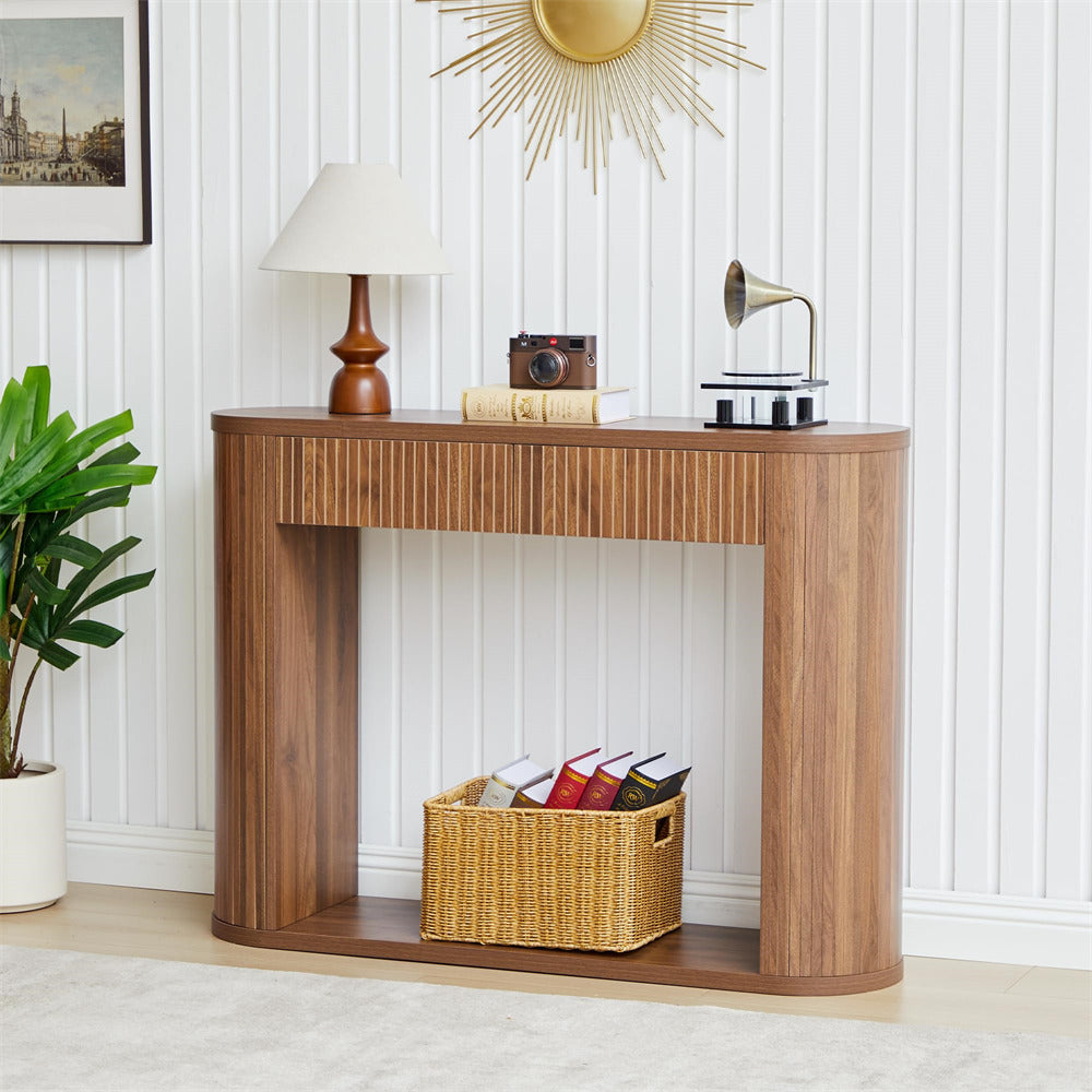 Wooden console table with decorative items in a room with white walls and a plant.