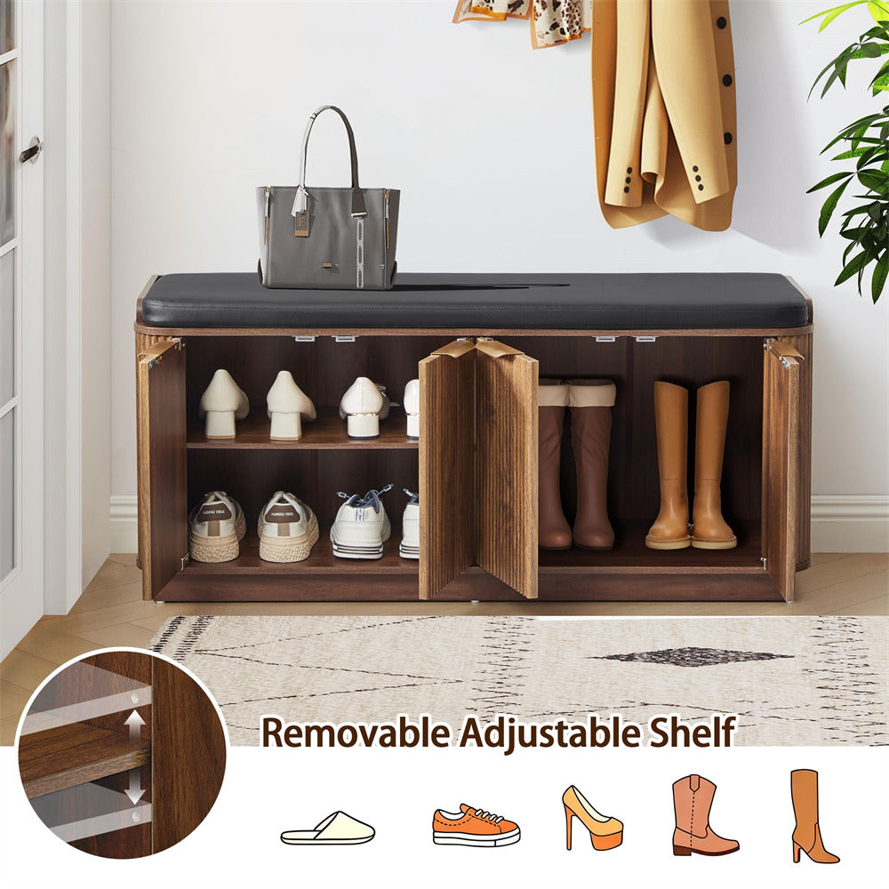 Wooden shoe bench with black cushioned top, shoes on shelves, and a coat hanging above.