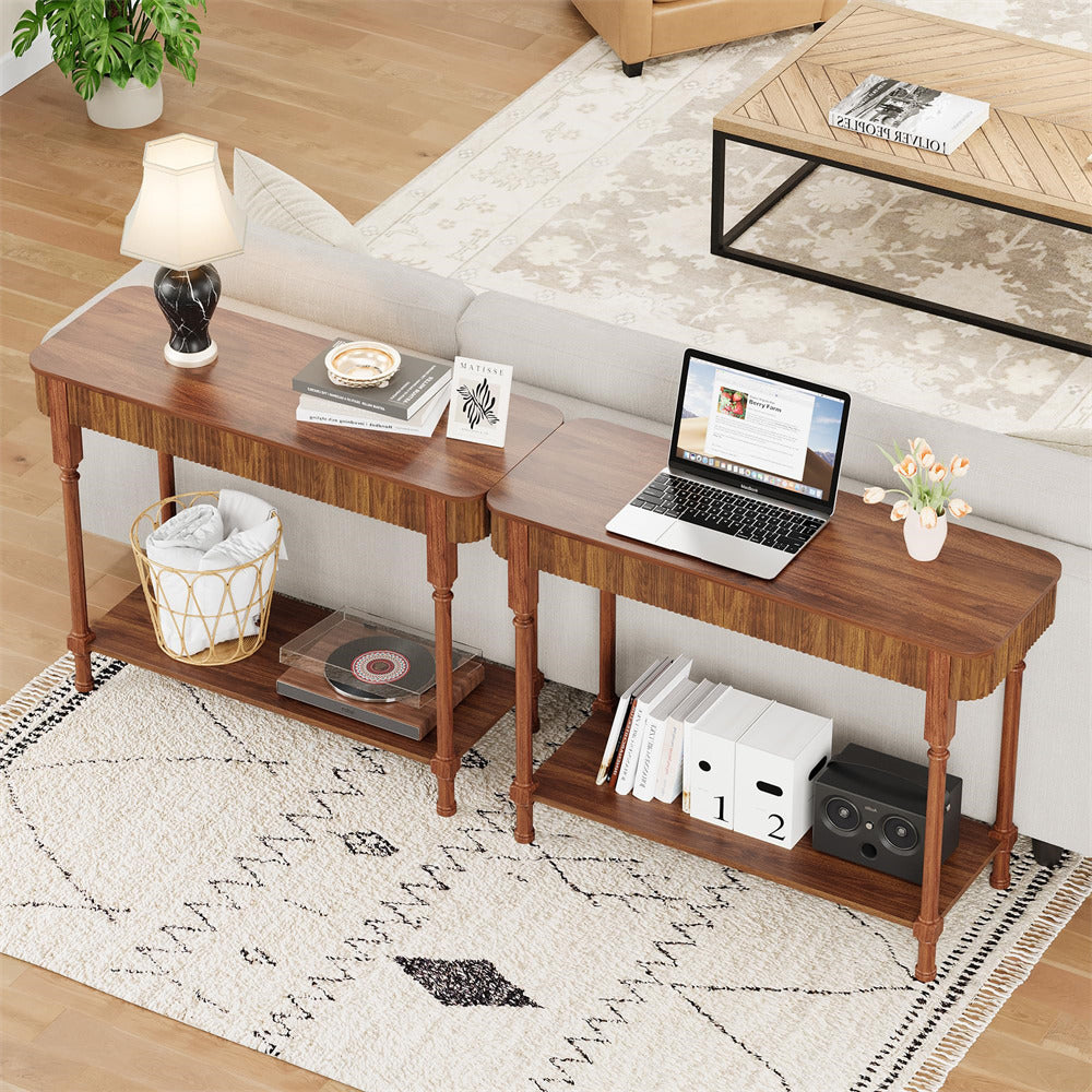 Wooden desk with laptop, books, and decor items in a living room setting.