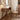 Wooden desk with chair in a room with a lamp and books.