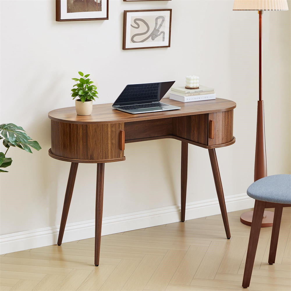 Wooden corner desk with a laptop, plant, and books in a room setting.