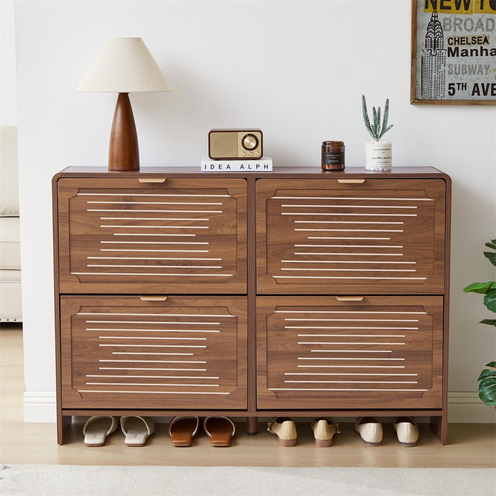 Wooden shoe cabinet with four drawers and shoe storage space, placed in a room with a lamp and decorative items.