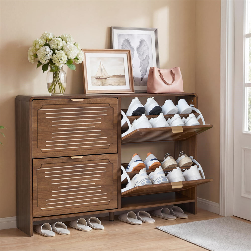 Wooden shoe cabinet with open doors displaying shoes, a vase of flowers, and framed pictures on top.