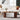 Modern living room with a white sofa, wooden coffee table, and decorative items.