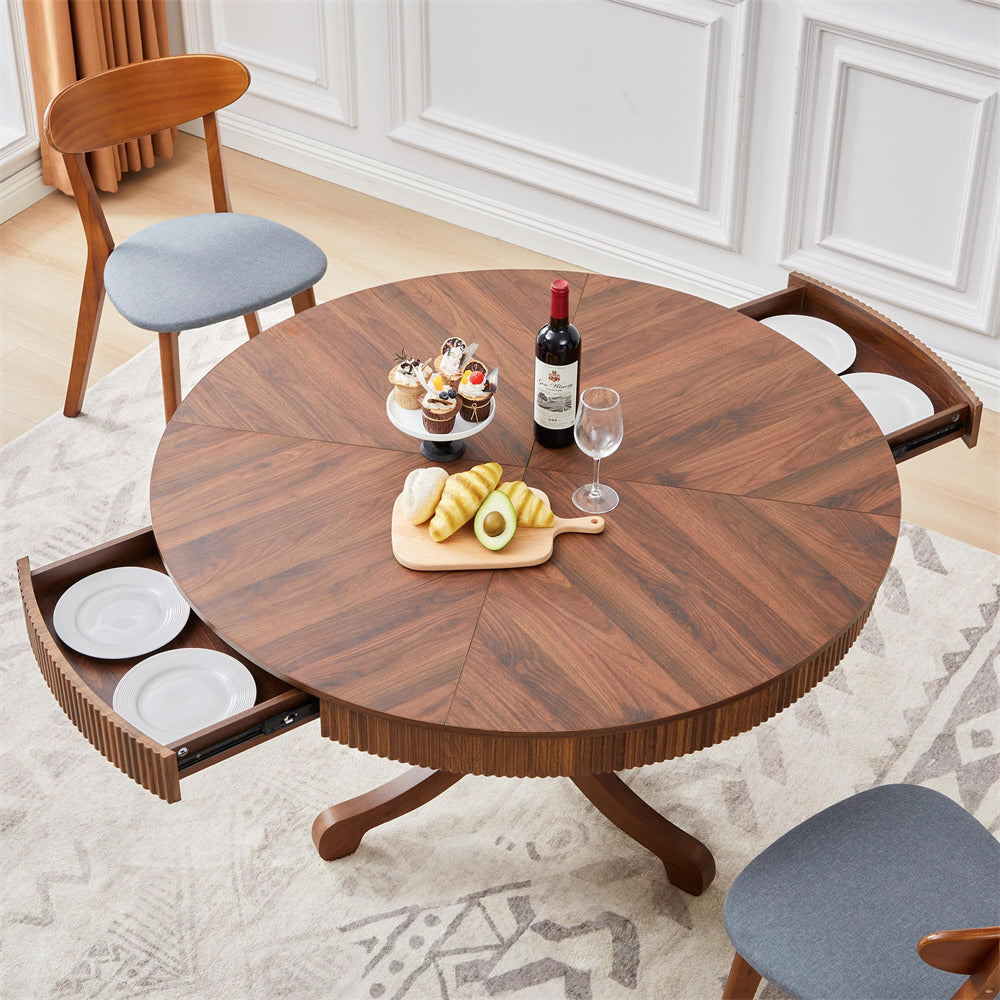 Round wooden dining table with storage drawers in a room setting.