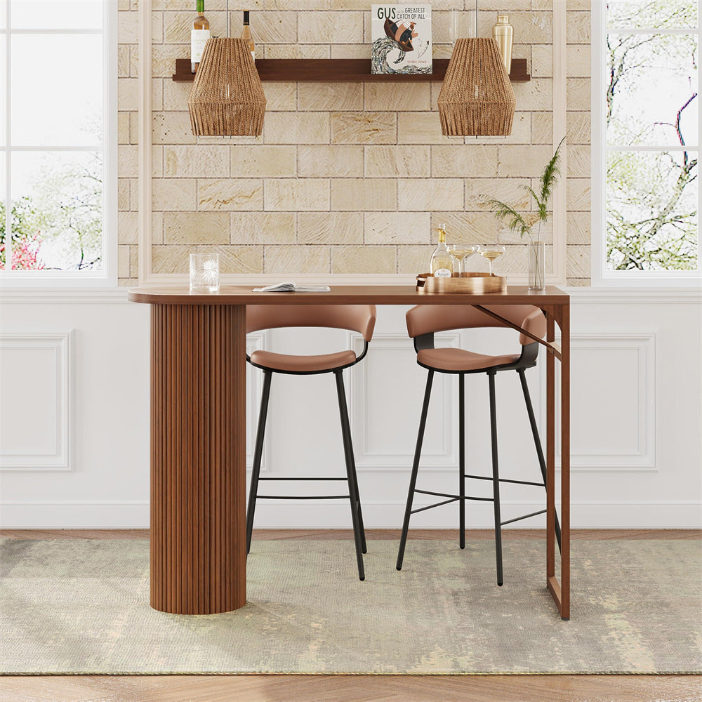 Wooden bar table with two stools against a tiled wall.