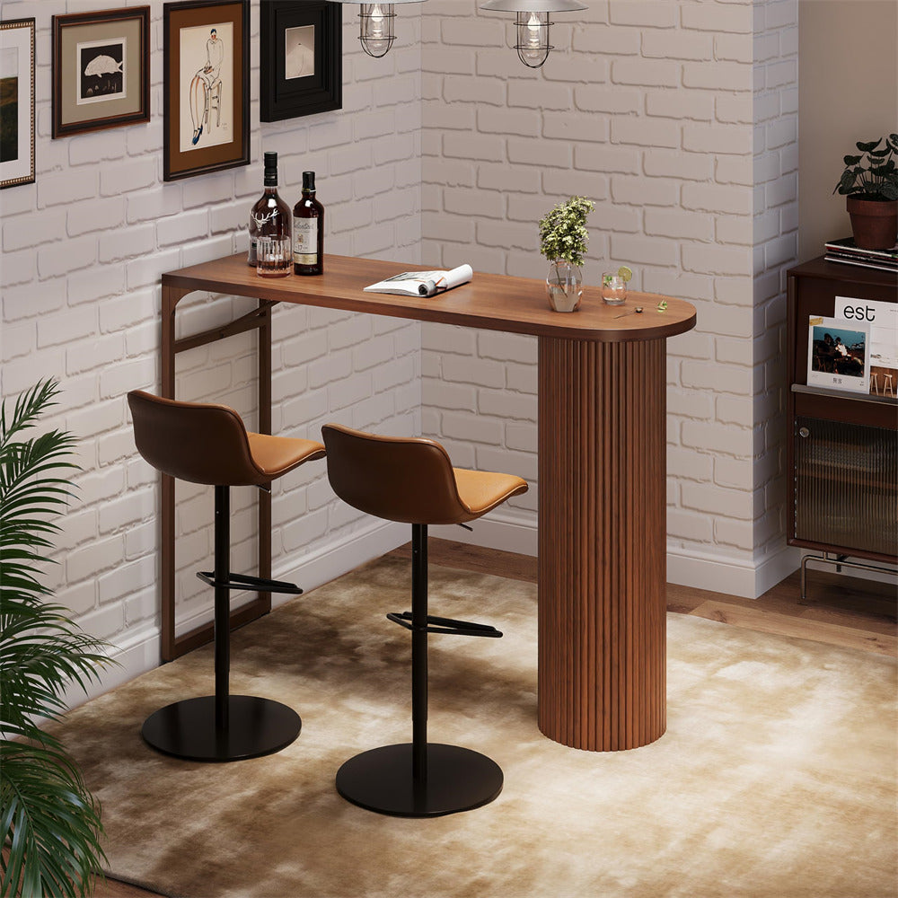 Wooden bar table with two stools against a white brick wall.