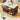 Wooden kitchen island with storage compartments and marble-like surface in a kitchen setting.