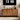 Wooden sideboard with decorative items and a digital clock on the wall.