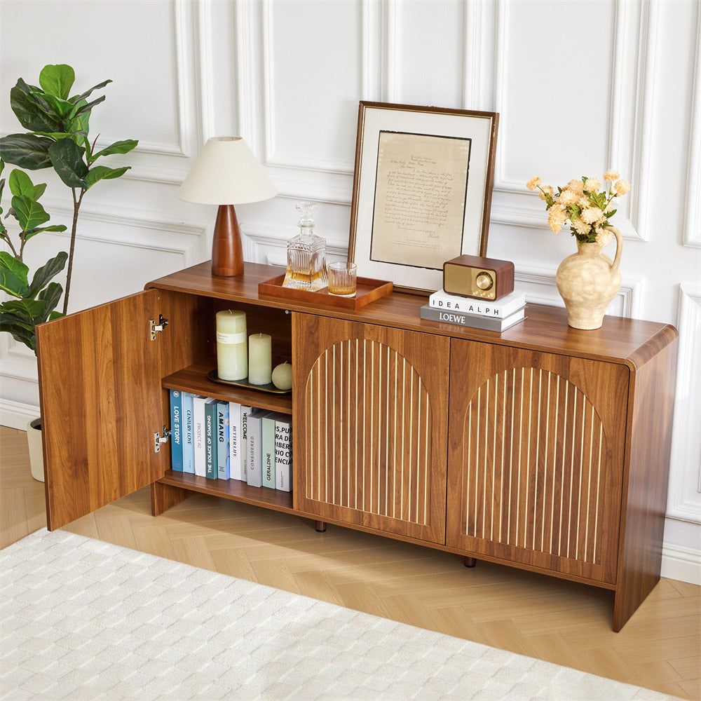 Wooden sideboard with decorative items in a room with a plant and lamp.