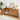 Wooden sideboard with decorative items in a room with a plant and lamp.
