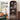 A tall wooden 2-level record shelf with an arched top, styled in a living room setting next to a green sofa and an acoustic guitar. The shelf is filled with vinyl records, speakers, a turntable, and CDs, with text overlays explaining the adjustable 15-inch shelf height.