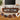 A mid-century modern wooden TV stand in a warm medium brown finish, styled in a living room setting with a wall-mounted TV, decorative objects, and flowers. Four circular inset detail images at the bottom highlight features like cable management, power outlets, elegant fluted design, and anti-slip pads.