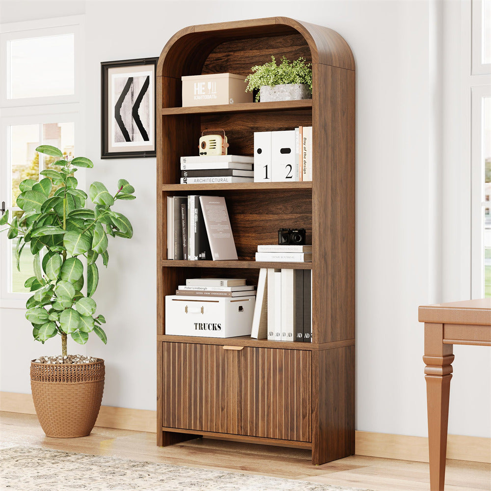 Wooden bookshelf with books and decor items in a room with a plant and table.