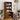 Wooden bookshelf with kitchen appliances in a room with chairs and a plant.