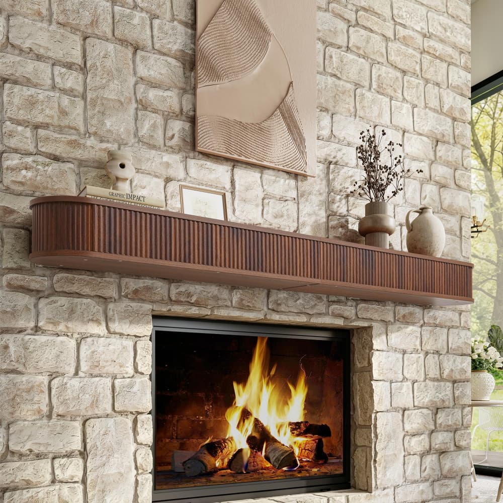 A modern brown slatted mantel shelf mounted above a fireplace in a light stone brick wall, styled with decorative vases, a small bird figurine, and wall art.