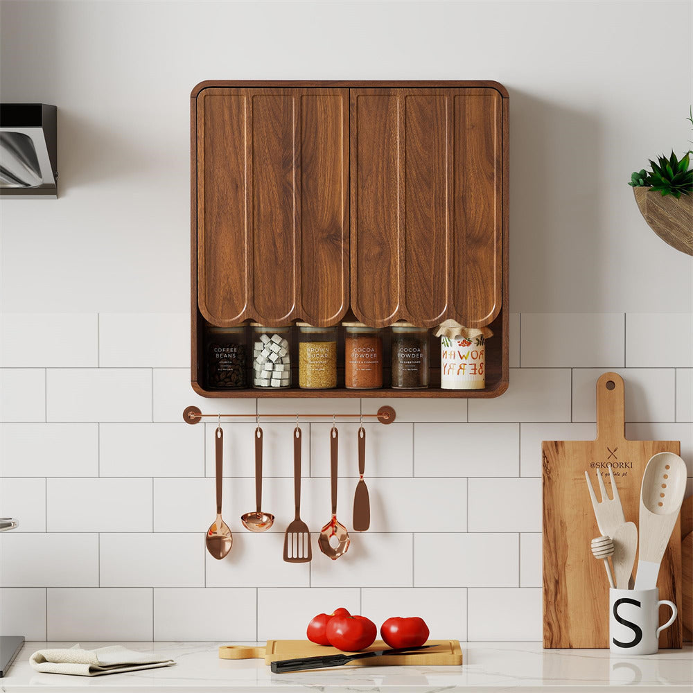 Wooden cutting board with storage compartments and hanging utensils on a kitchen wall.