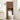 Wooden over-the-toilet cabinet in a bathroom setting with a white toilet and decorative elements.