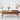Wooden coffee table with a vase, fruit plate, and newspaper in a living room setting.