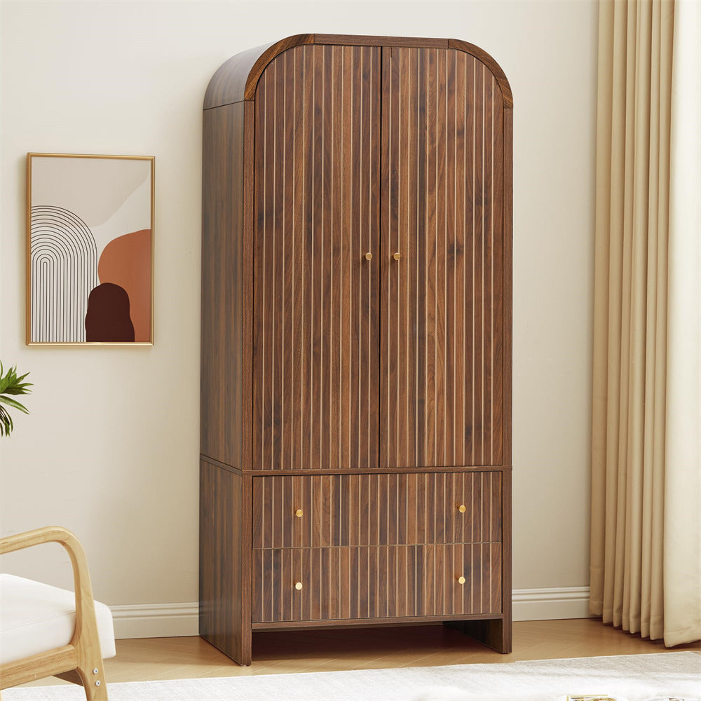 Wooden wardrobe with arched top in a room with a painting and chair.