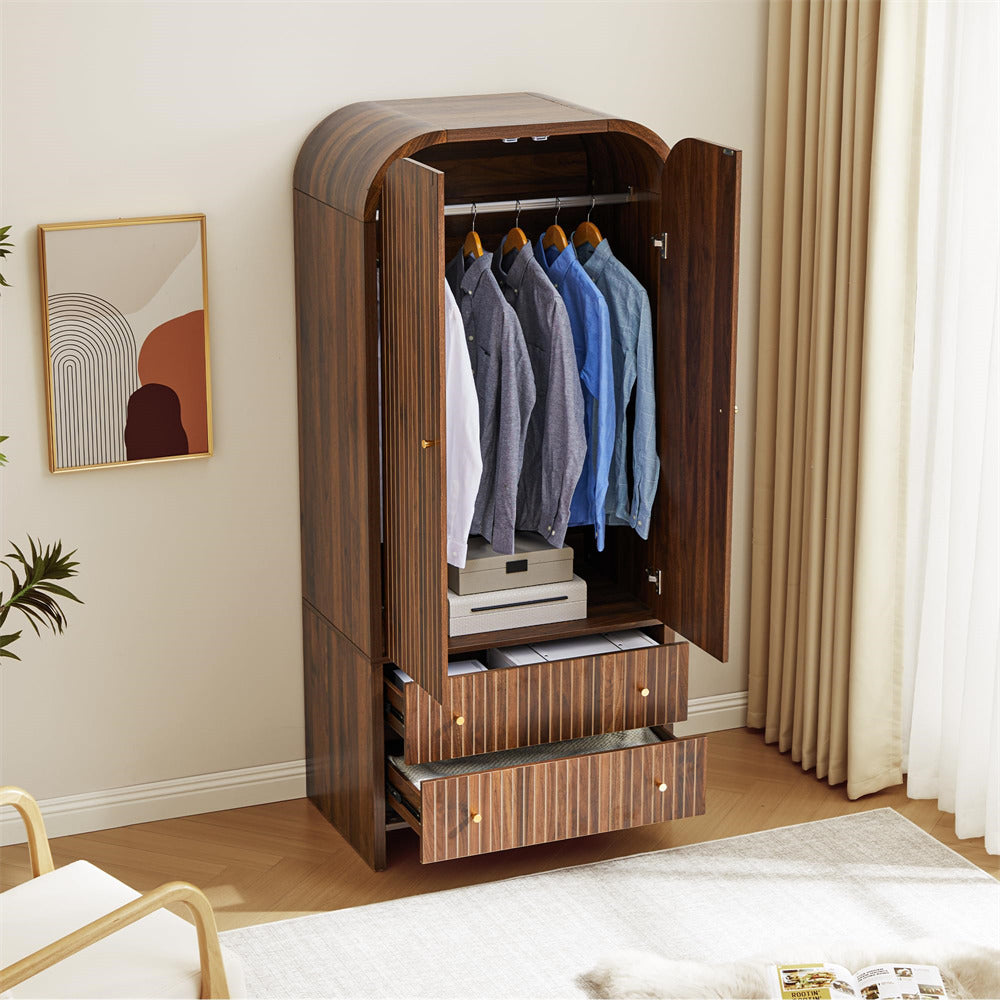 Wooden wardrobe with open doors displaying clothes in a room with a bed and wall art.