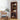 Wooden bookshelf with decorative items in a room with a table and chairs.