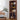 Wooden bookshelf with decorative items in a room with a table and plant.