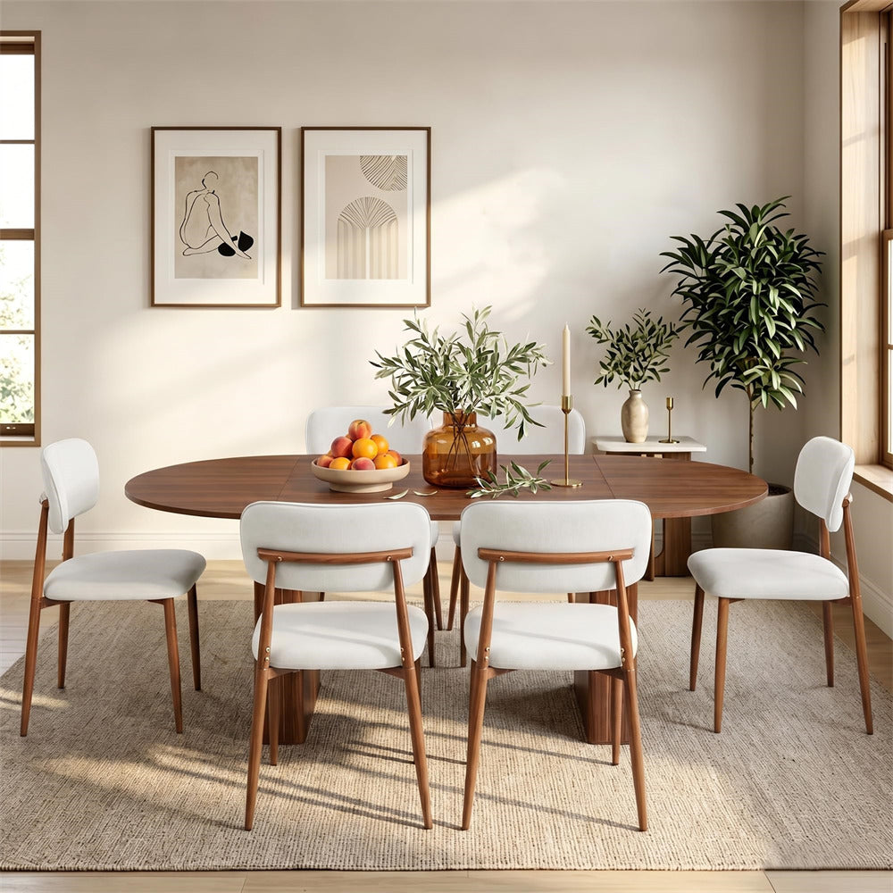 A mid-century modern dining set featuring a round wooden table and six matching chairs with white upholstered seats and wooden frames, styled in a bright, contemporary dining room.