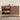Wooden shoe rack with multiple shelves and a cabinet against a beige wall.