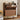 Wooden shoe cabinet with open door displaying shoes, a clock, and a bag on top, with another shelf below.